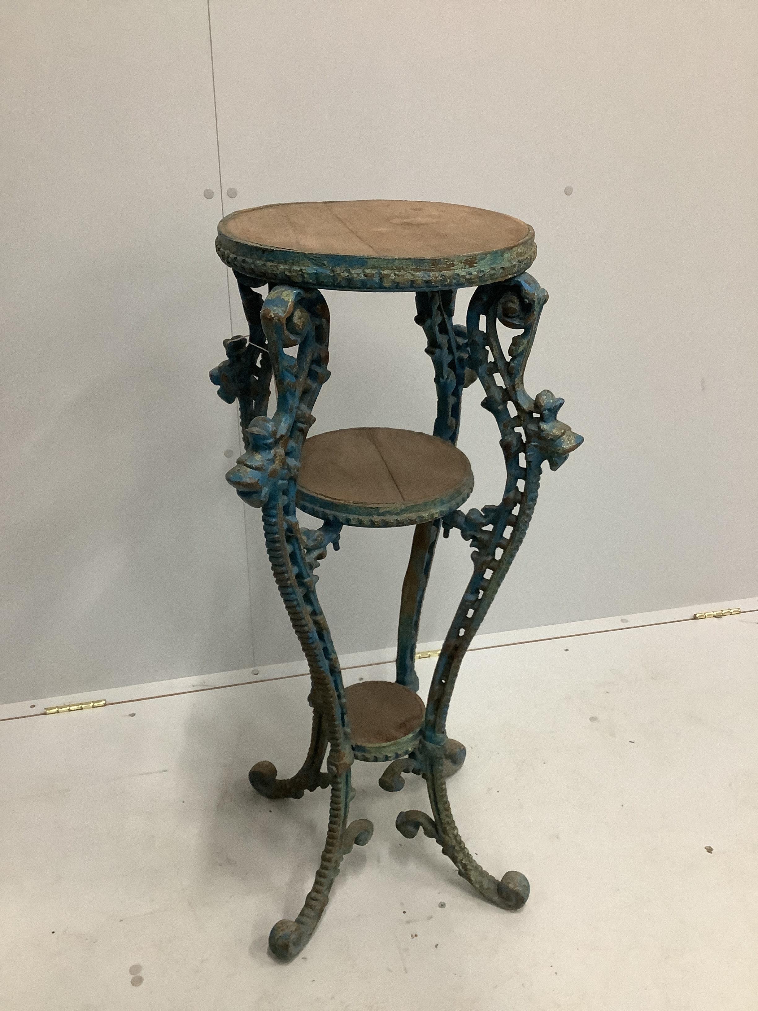 A circular painted three tier cast iron and wood jardiniere stand, width 50cm, height 95cm